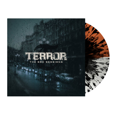 Image of terror- the bbc sessions vinyl sleeve with a half clear, half orange with black splatter vinyl against a white background. The terror artwork features a photo of a street with cars lined up against the side of the street. There is a large building next to where the cars are parked. there is rain all over the cover, like this was photographed from the inside of a window. the image is a blue/grey color. Across the front in white text reads terror- the bbc sessions.