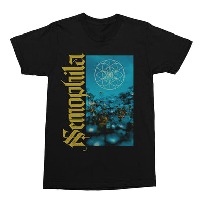 Black short sleeve shirt with Nemophila written vertically in yellow text along the side of rectangular artwork. The art work is a blue background with dead flowers. 