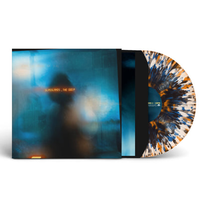 Vinyl sleeve with a clear with blue, orange, and black splatter vinyl sticking halfway out of the vinyl sleeve against white background. The album artwork is a blurred blue and white color, and there is a faded silhouette of a person in the center. Across their head in an orange glowing analog text reads "glasslands, the deep".