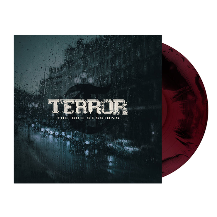 Image of terror- the bbc sessions vinyl sleeve with a black and maroon colored vinyl against a white background. The terror artwork features a photo of a street with cars lined up against the side of the street. There is a large building next to where the cars are parked. there is rain all over the cover, like this was photographed from the inside of a window. the image is a blue/grey color. Across the front in white text reads terror- the bbc sessions.