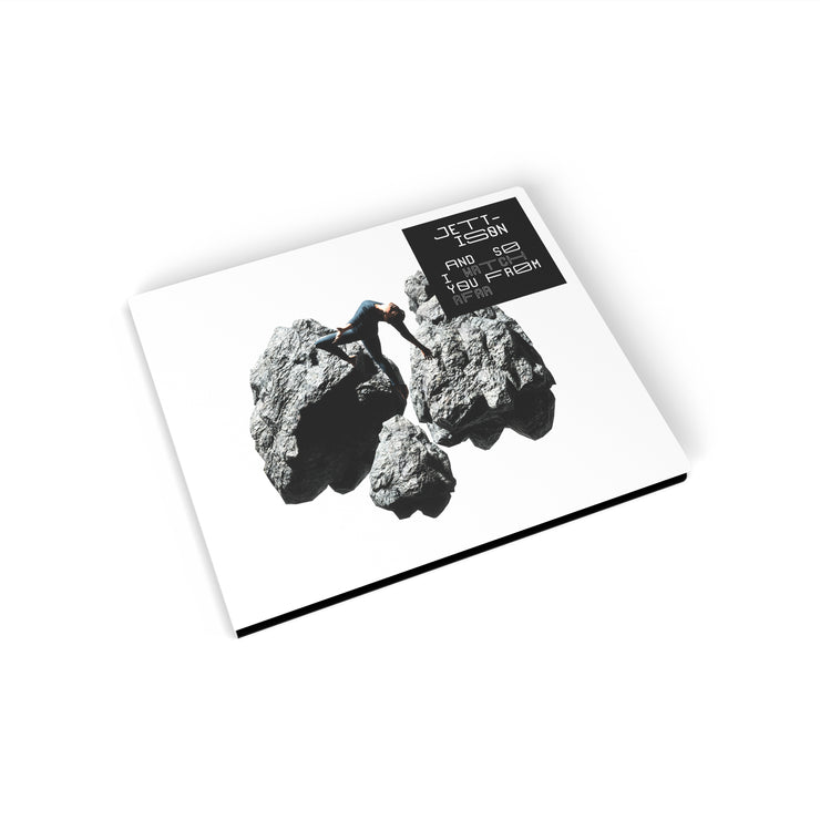 Cd cover against a white background. The cover features three large rocks in grey, and a person is standing on one of them. The right corner has a black square, the text inside says "jettison", "and so I watch you from afar".
