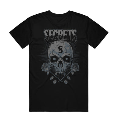 Image of a black tshirt against a white background. Across the front in a grey to black gradient text reads "secrets". Below this is a graphic of a skull with an S on its head. There are two roses, crossed beneath the skull. 