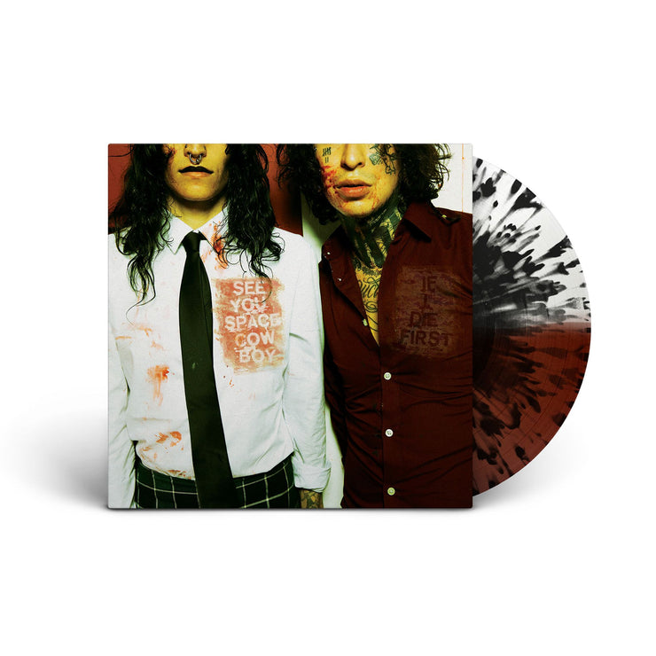 Vinyl sleeve with half clear half oxblood with black splatter vinyl sticking out of the sleeve against white background. The album cover has an image of two people photographed from the waist to their noses facing the camera. one wears a button up with a tie and the other a button up with a few buttons unbuttoned. The shirt of the person on the left says see you space cowboy. the shirt of the person on the right says if i die first.