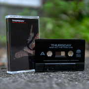 Black cassette with THURSDAY written in the top left corner in white. Below that there is smaller text that says WAR ALL THE TIME LIVE in red font. The artwork is a drawing of a bird flying downwards. There is a black cassette tape to the right of the case with text that says THURSDAY WAR ALL THE TIME LIVE. Both are standing on top of asphalt.