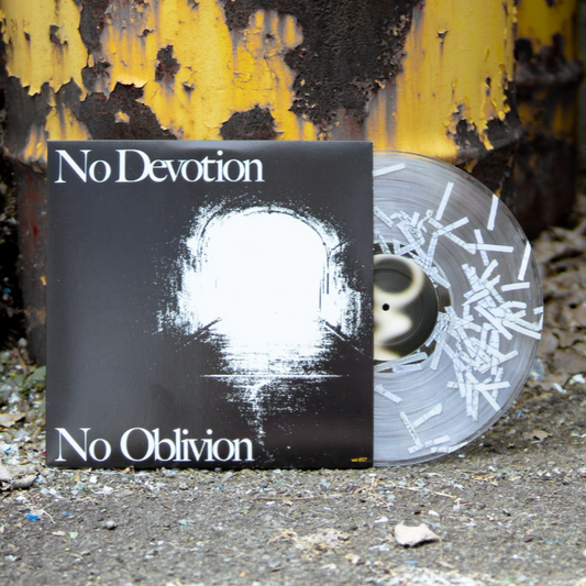 A limited edition clear vinyl LP with white streaks from No Devotion is partially pulled from the No Oblivion album cover, featuring a white abstract design and leaning against a rusty yellow metal outdoor surface.